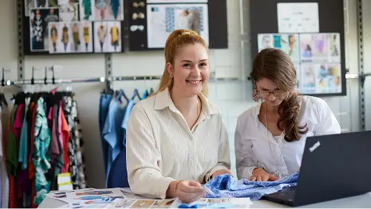 Mitarbeitende an einem Schreibtisch in der Zentrale